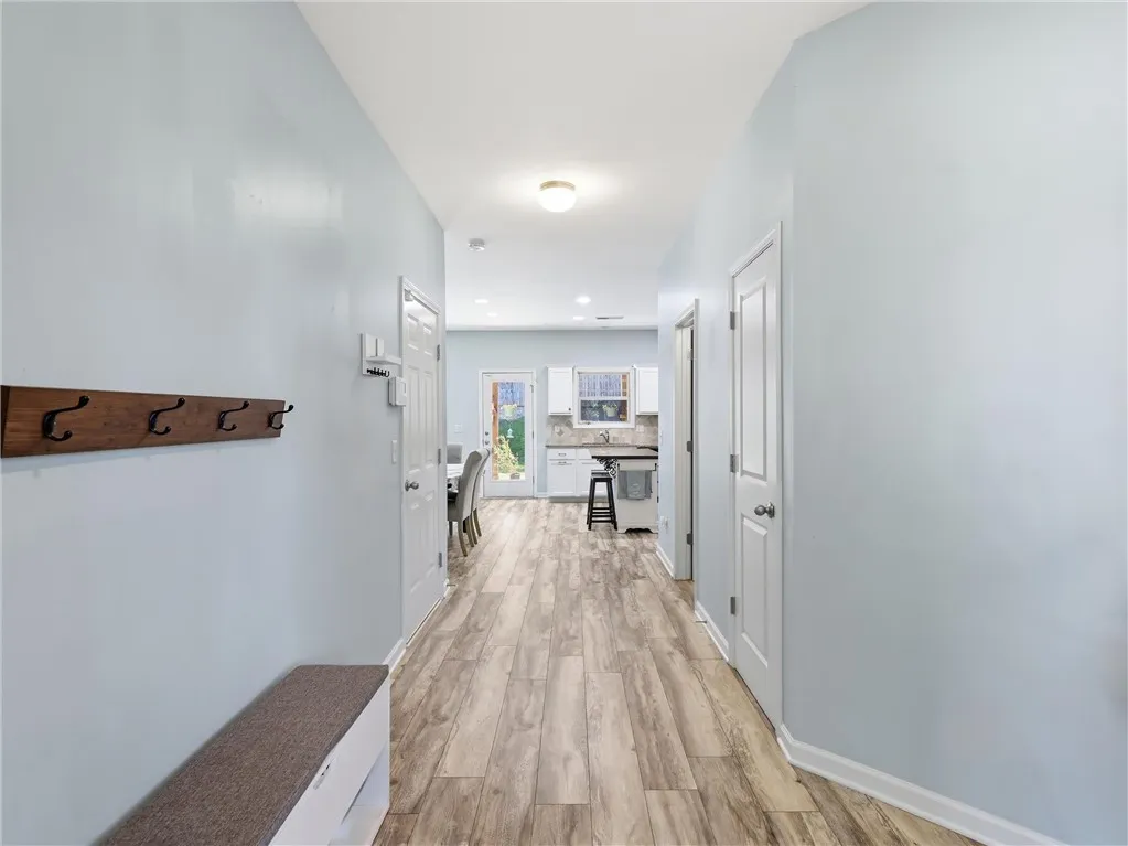 A welcoming entryway with durable flooring extends towards a well-appointed kitchen.