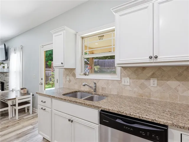 Granite counters and stainless steel appliances adorn this efficient kitchen with a view to the backyard.