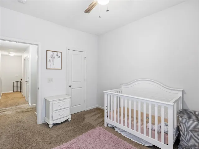 Soft carpet and clean walls define this peaceful and inviting secondary bedroom, perfect for rest.