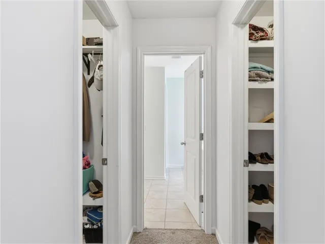 A well-lit hallway offers access to practical built-in storage solutions.