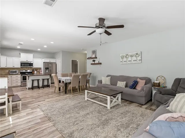 An inviting open-concept living space features a functional kitchen, dining area, and comfortable lounge.