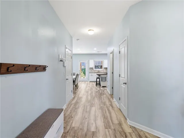 A welcoming entryway with durable flooring extends towards a well-appointed kitchen.