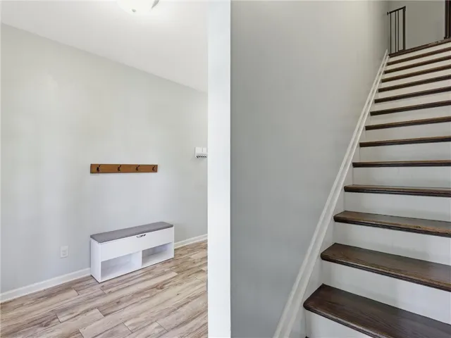 A welcoming entry features durable laminate flooring and a well-crafted staircase with rich wood treads.