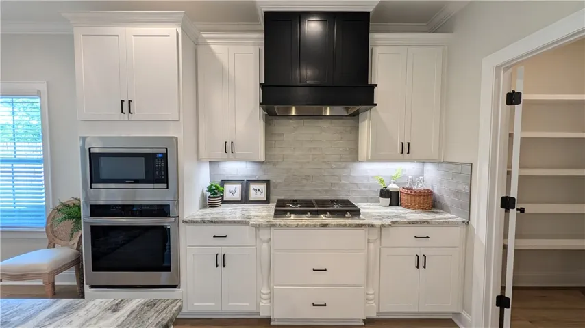 A well-appointed kitchen features a gas cooktop, built-in microwave and oven, and a conveniently located pantry.