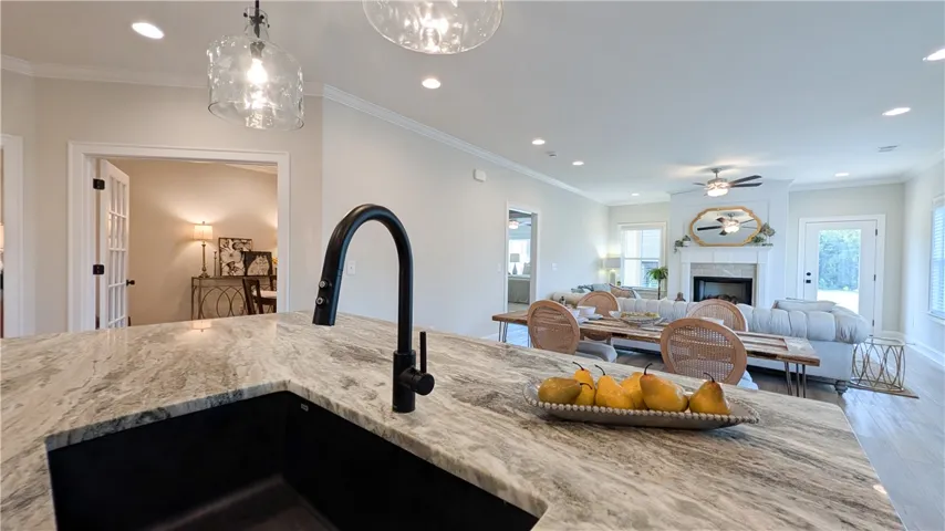 This contemporary kitchen island showcases a deep sink and stone countertop, seamlessly connecting to an open living area.