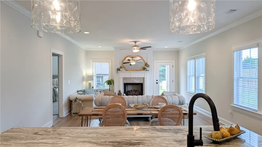 The open-concept living and dining areas flow seamlessly, centered around a cozy fireplace, perfect for entertaining.