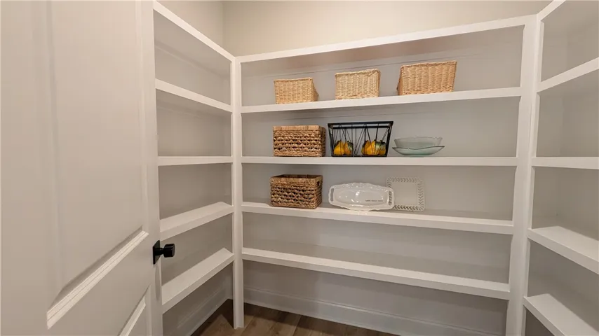 This spacious pantry features abundant built-in shelving, providing extensive storage and organization for any kitchen.