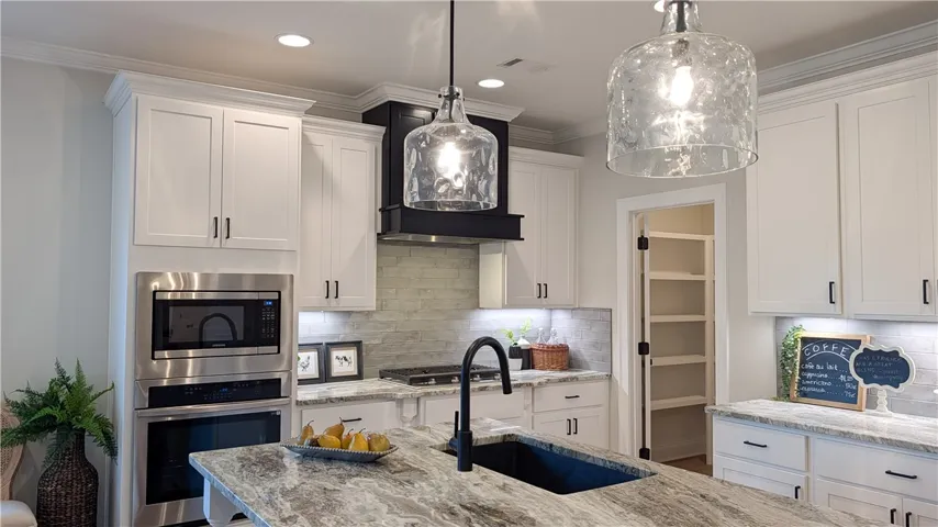 This gourmet kitchen showcases stainless steel appliances, a generous island, and a convenient walk-in pantry.