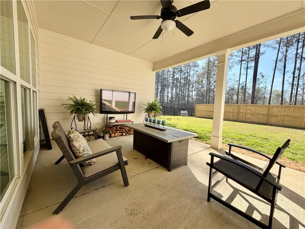 A spacious covered patio invites relaxation with a backdrop of a private fenced yard and mature trees.