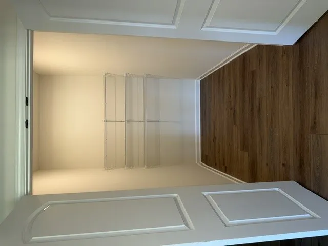 A well-organized closet offers ample storage with integrated shelving and rich hardwood flooring.
