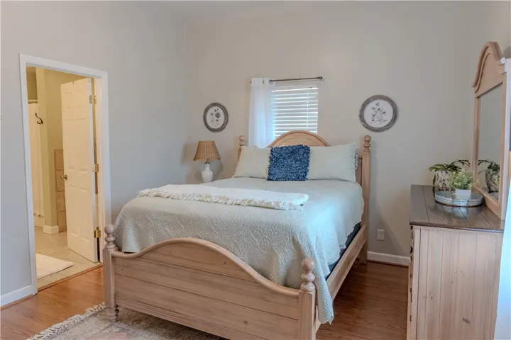 Master bedroom with wood floor & en-suite bathroom.
