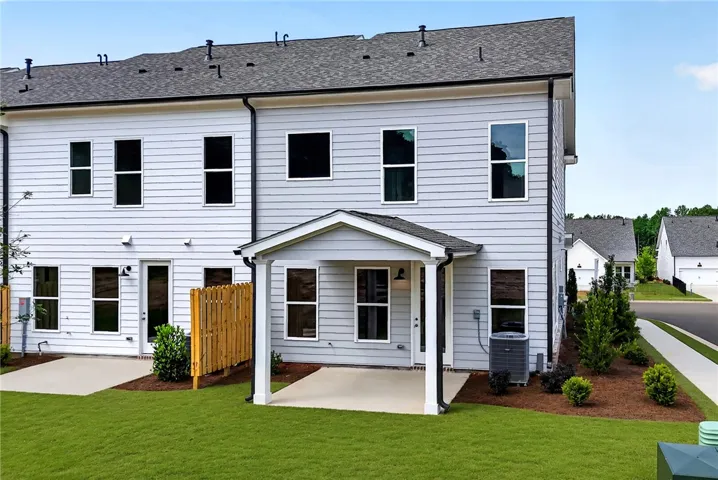 A well-maintained lawn and paved patio enhance the back of this appealing two-story home.