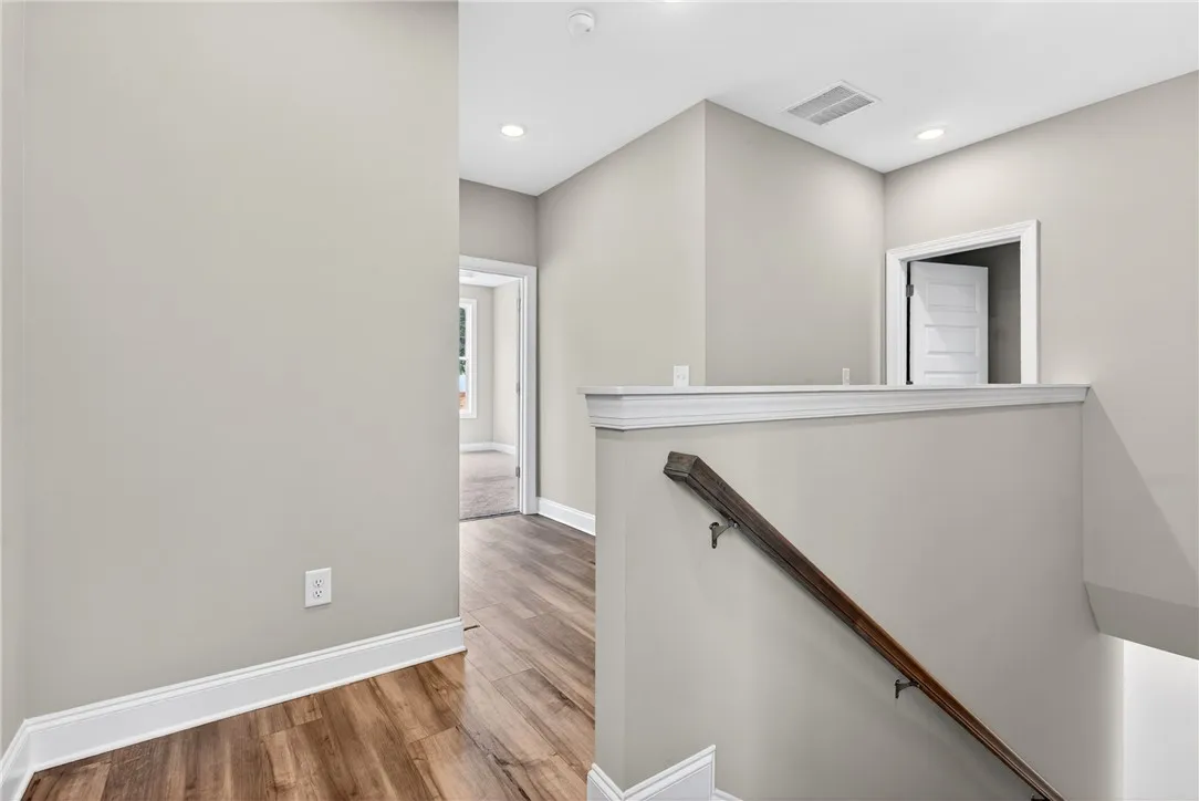 Natural light illuminates this elegant hallway with rich wood-look flooring.
