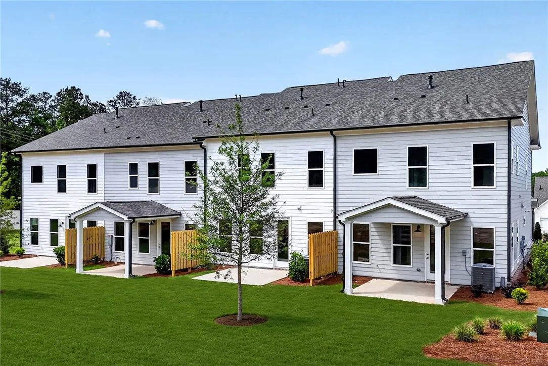 A row of modern townhomes showcases private covered patios and meticulously maintained backyards.