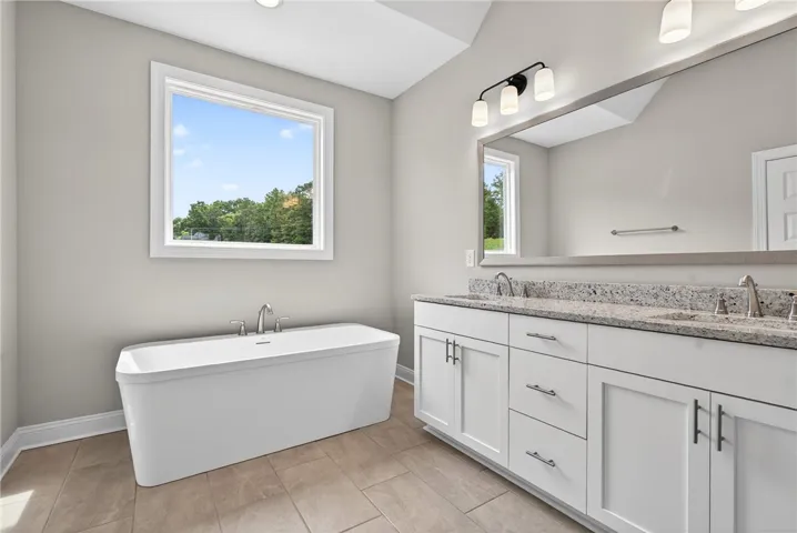 Luxurious bathing area features a deep soaking tub and a spacious double vanity with ample counter space.