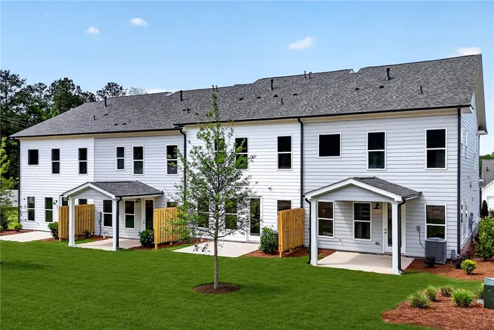 A row of modern townhomes showcases private covered patios and meticulously maintained backyards.
