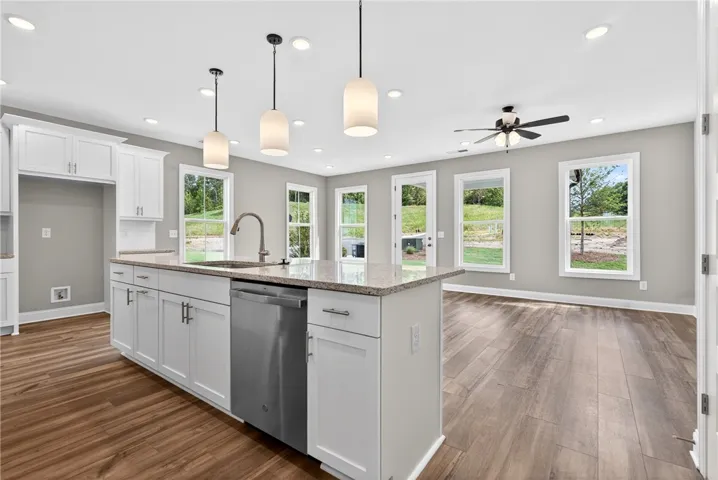 A well-lit kitchen island with a sleek dishwasher anchors this open-concept living space.