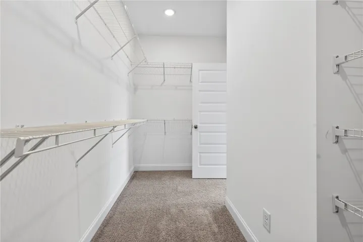 A generously sized walk-in closet with ample shelving provides abundant storage solutions.