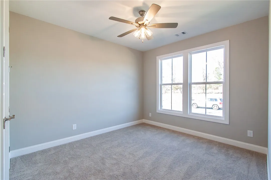 This airy bedroom offers a tranquil retreat with soft carpet and ample natural light. Photos are not of subject property. Photos are of the same floorplan of a completed home.