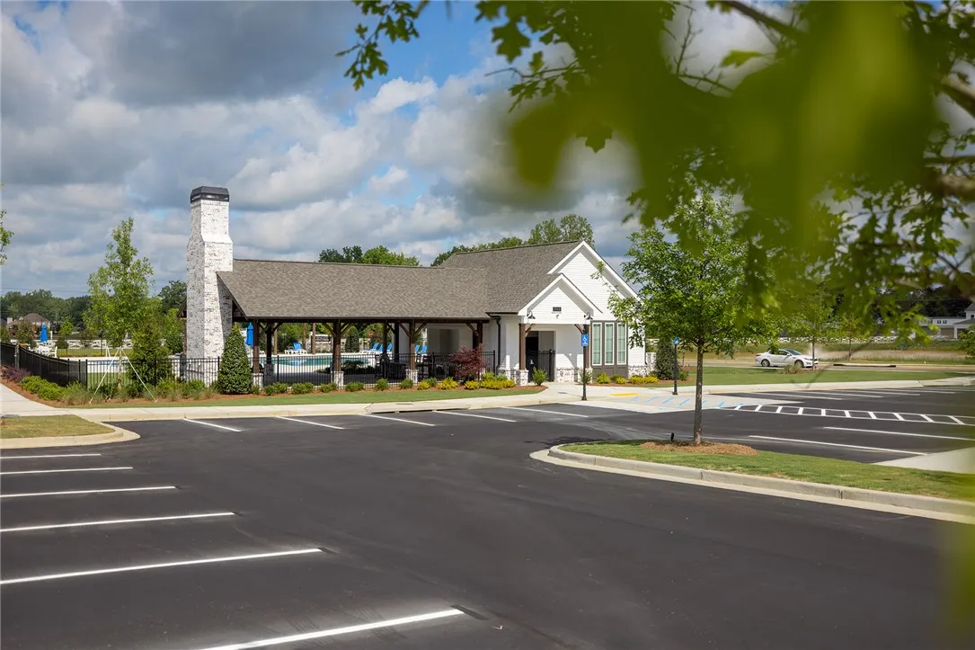 This modern clubhouse features a classic white facade, dark roof, and a welcoming covered patio.