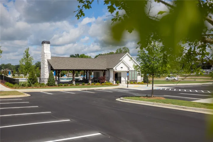 This modern clubhouse features a classic white facade, dark roof, and a welcoming covered patio.