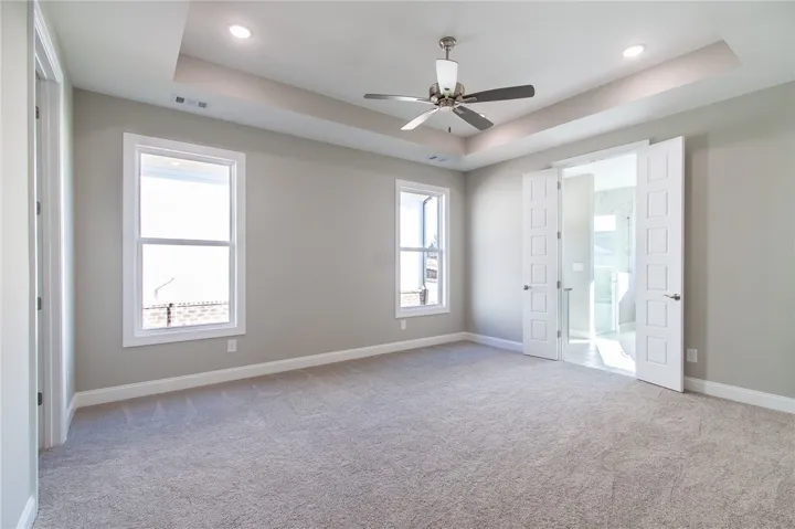 An inviting room awaits with soft carpet and abundant natural light. Photos are not of subject property. Photos are of the same floorplan of a completed home.