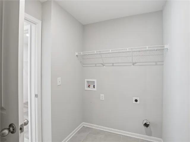 Laundry room that adjoins the primary suite and hallway