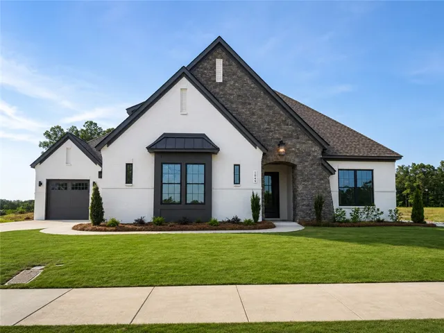 A striking modern home with contrasting white brick and dark stone accents offers inviting curb appeal.