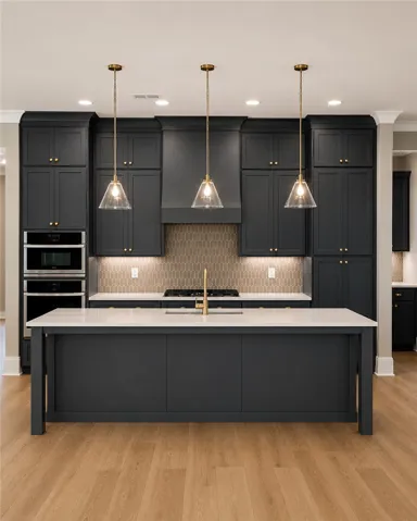 A well-appointed kitchen showcases rich cabinetry and an expansive island with integrated appliances, perfect for culinary endeavors.