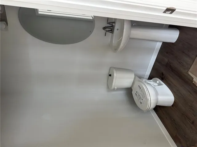This clean and functional bathroom features a classic pedestal sink, a toilet, and lvp flooring.