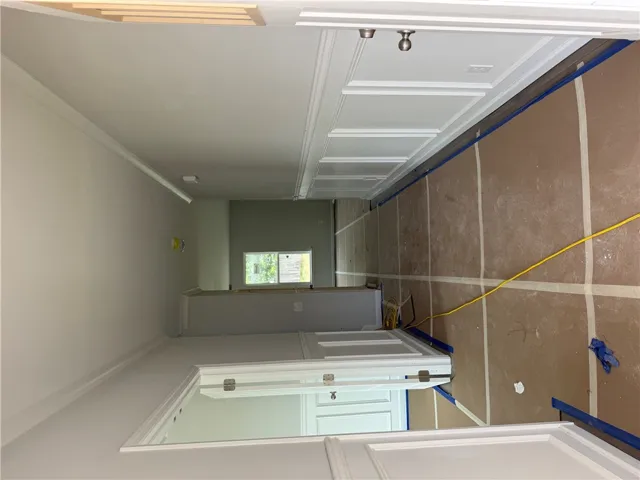 An inviting hallway with crown molding and unique wall paneling.