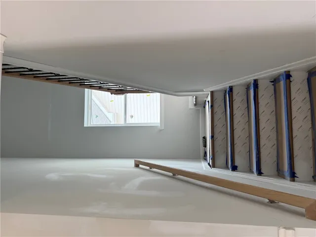 This spacious interior offers an elegant stairway with natural light through a clear window.