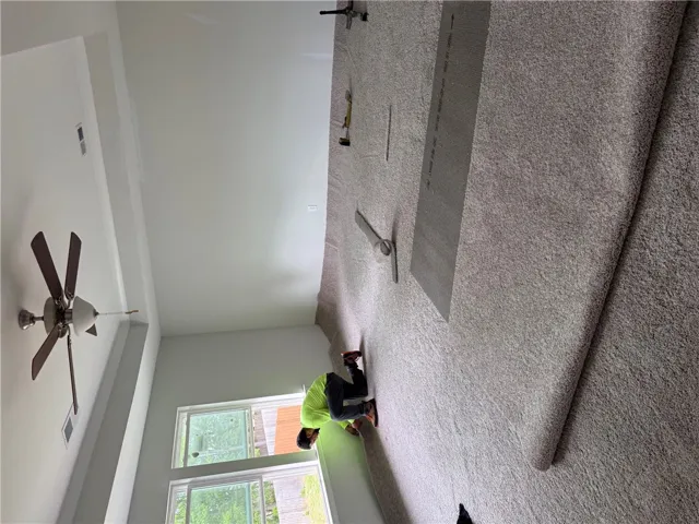This primary bedroom features a tray ceiling and ample natural light, creating an open and airy atmosphere.