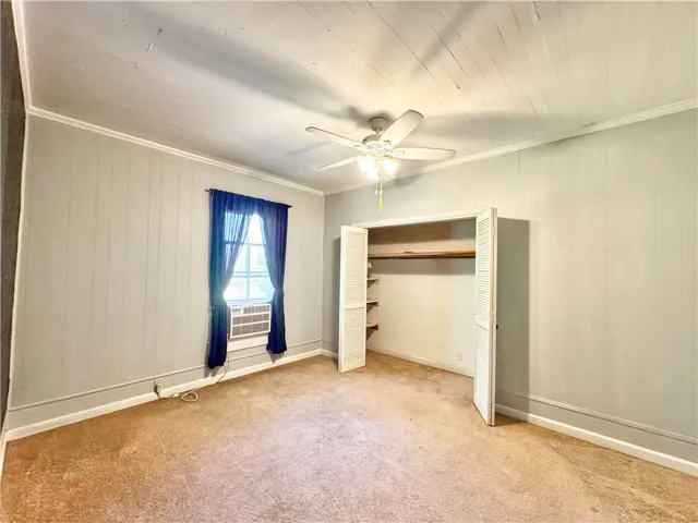 This spacious bedroom offers ample storage, bright window, and comfortable flooring.