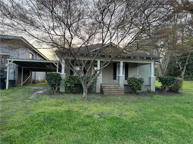 This charming home offers a welcoming facade with a cozy porch and mature landscaping.