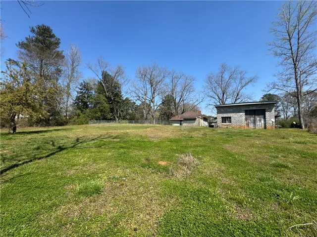 This spacious lot features mature trees and a sturdy outbuilding, offering ample potential.