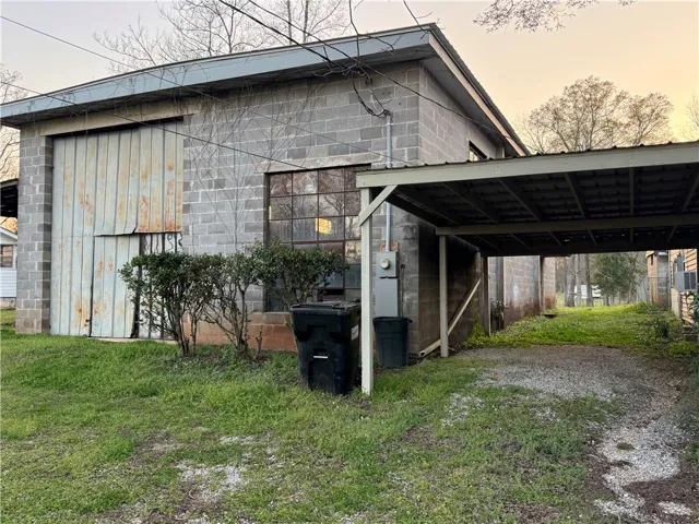 This structure features a practical carport, ample parking, and durable block construction.