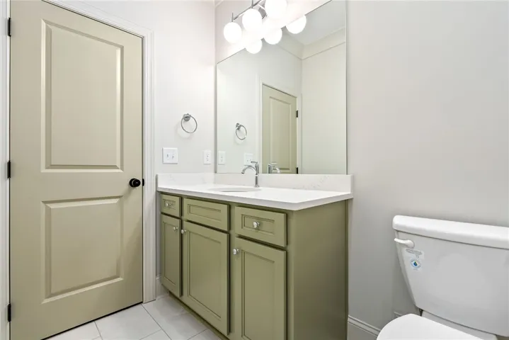 This clean bathroom features a spacious vanity and ample lighting, perfect for any morning routine.