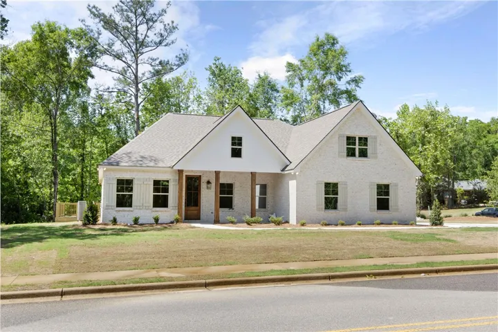 This charming residence features a timeless exterior with architectural details and a welcoming front entrance.