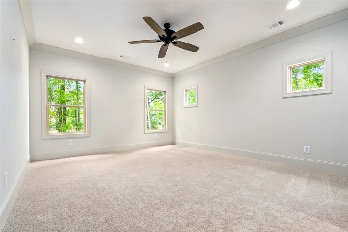 This spacious room features ample natural light and a comfortable, plush carpeted floor.