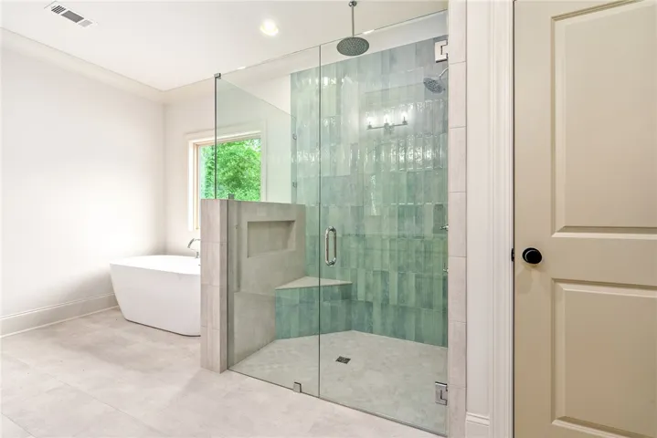 This serene bathroom offers a spacious walk-in shower and a freestanding tub for ultimate relaxation.