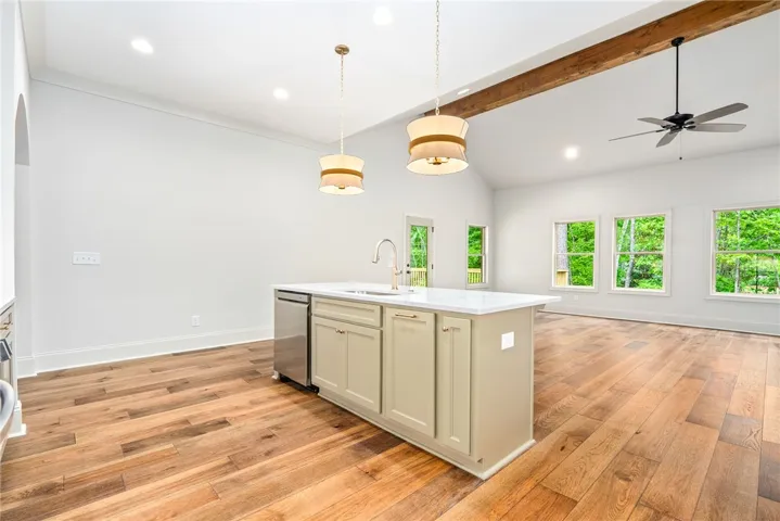 This bright kitchen features an island, ample cabinetry, and rich hardwood flooring throughout the open layout.
