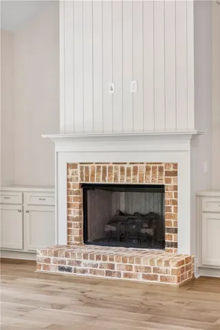 This inviting fireplace, adorned with classic brickwork, anchors the room with enduring charm.