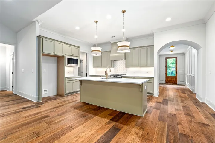 This spacious kitchen offers a central island, modern appliances, and beautiful hardwood floors.