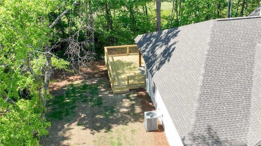 This newly constructed deck offers a tranquil outdoor retreat amidst lush greenery.