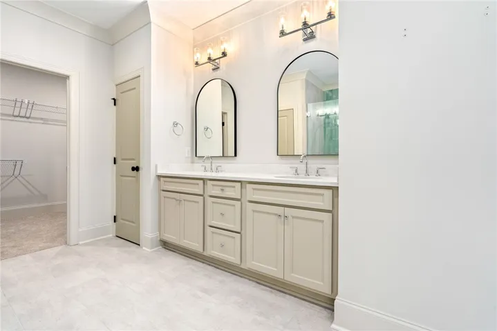 This spacious bathroom offers dual vanities and modern fixtures, perfect for daily routines.