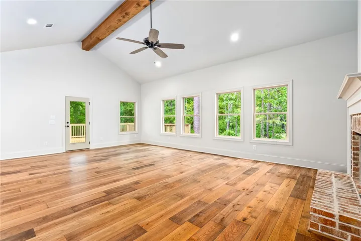Bright and open living area with rich hardwood floors and a striking fireplace.