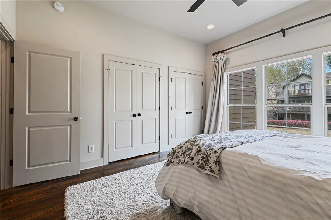 Wood flooring and large windows create a well-lit and comfortable bedroom retreat.