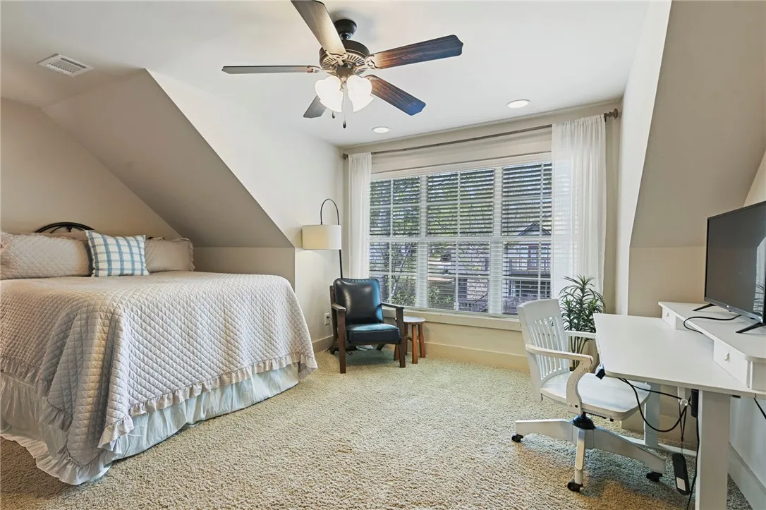 A cozy bedroom with a ceiling fan and natural light offers a peaceful retreat.