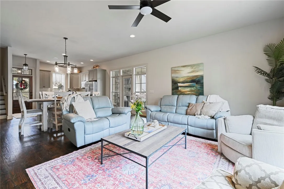 An inviting open-concept living area boasts rich hardwood floors and a modern ceiling fan.